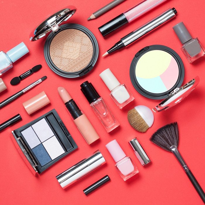Beauty, decorative cosmetics. Makeup brushes set and color eyeshadow palette on pink and blue background , flat lay, top view, Minimalistic style.red background.